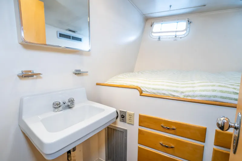 Slide: The Image of Compact yacht cabin with sink, bed, and storage on a 1965 Burger Motoryacht. - 43
