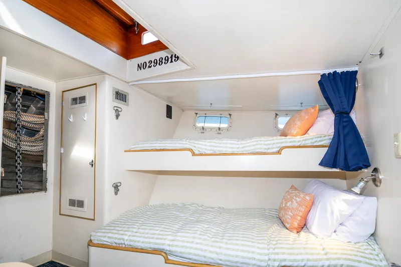 Slide: The Image of Cozy cabin with bunk beds on a 1965 Burger Motoryacht, featuring nautical decor and porthole windows. - 47
