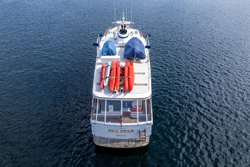 Slide: The Image of 1965 Burger Motoryacht on water, aerial view, with lifeboats and covered equipment on deck. - 7