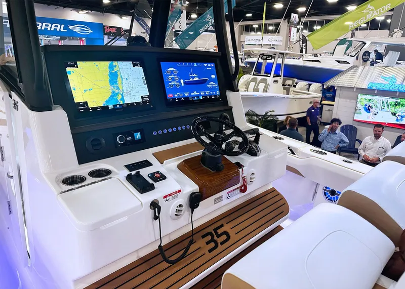 Slide: The Image of 2025 Regulator 35 boat dashboard with navigation screens at a boat show. - 8