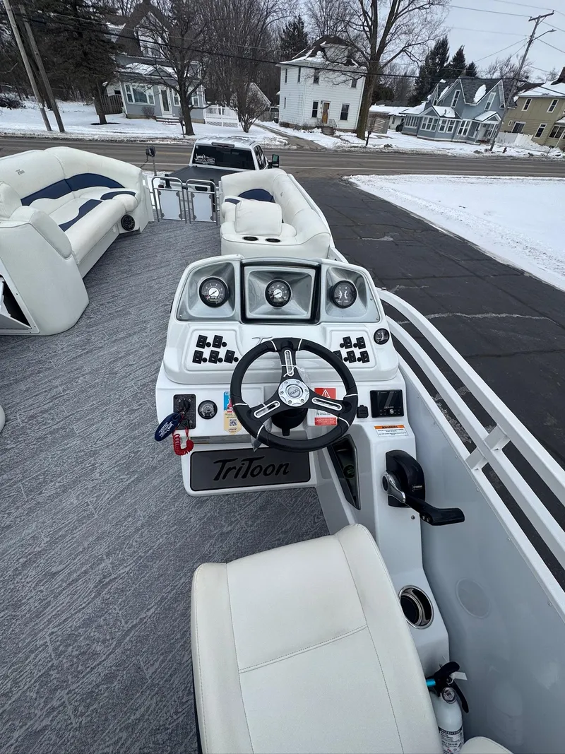 Slide: The Image of 2022 JC Neptoon 25TT boat interior with steering console and seating, parked on snowy pavement. - 7