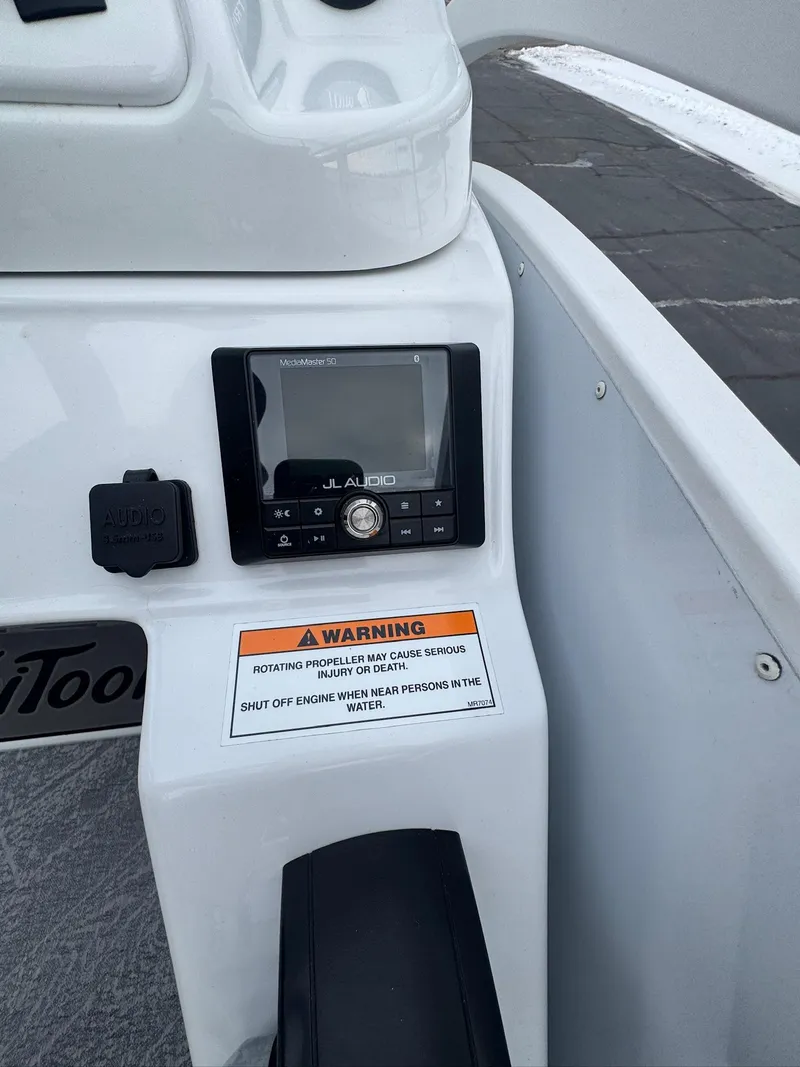 Slide: The Image of Control panel of 2022 JC Neptoon 25TT boat with warning label and display screen. - 8