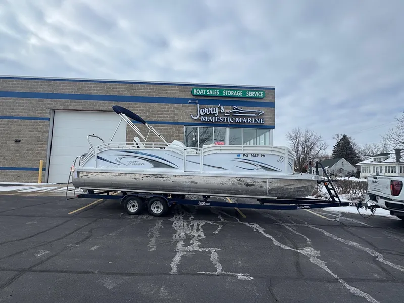 The Image of 2022 JC Neptoon 25TT pontoon boat on trailer outside marine sales and service building. - 0