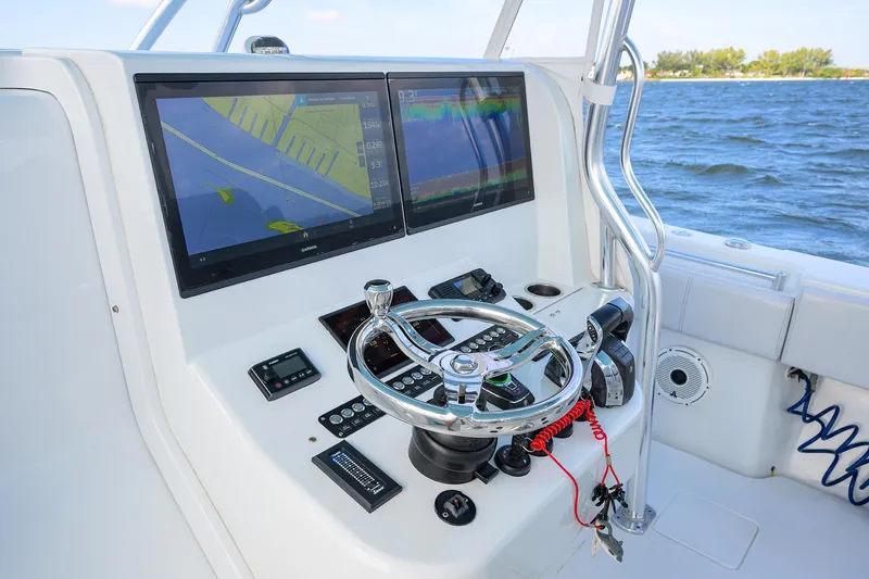 Slide: The Image of 2022 Contender 44FA boat dashboard with dual navigation screens and steering wheel. - 10