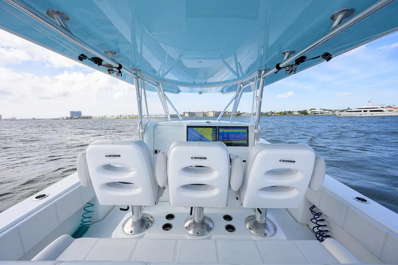 Slide: The Image of 2022 Contender 44FA boat interior with three white seats and ocean view. - 11