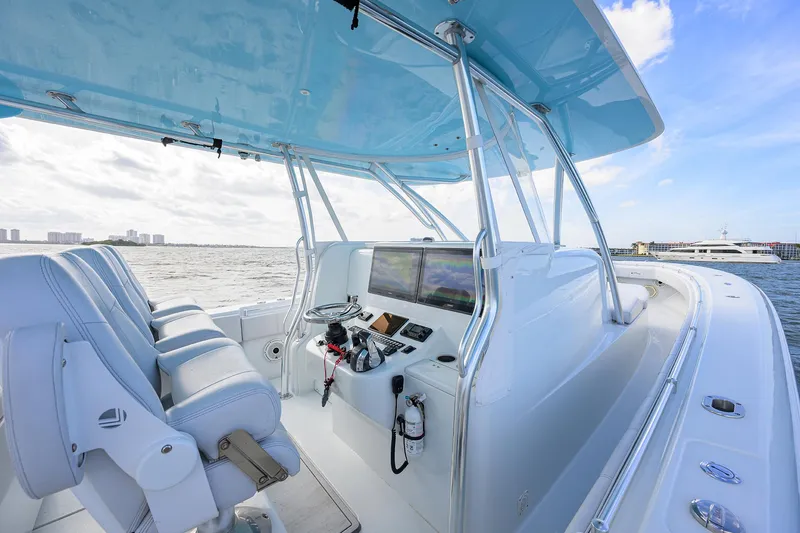 Slide: The Image of 2022 Contender 44FA boat cockpit with modern controls and ocean view. - 13