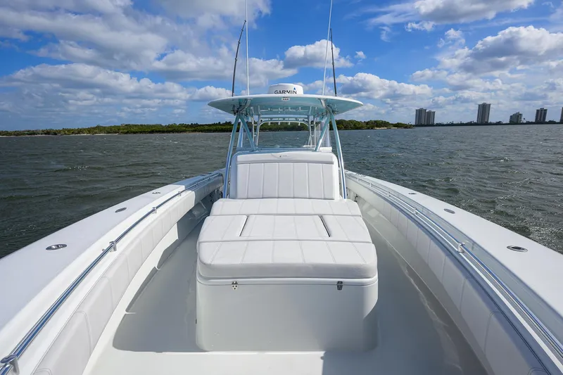 Slide: The Image of 2022 Contender 44FA boat on water, featuring spacious deck and seating under blue sky. - 22