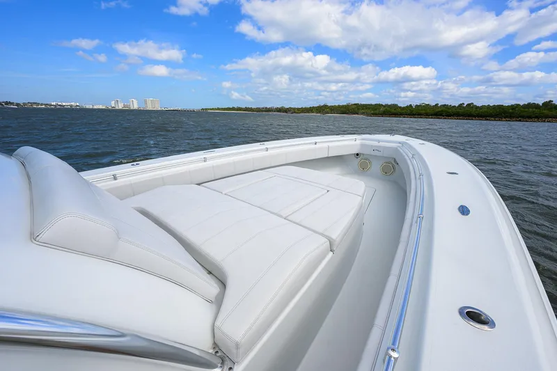 Slide: The Image of 2022 Contender 44FA boat with white seating, cruising on a calm sea under a blue sky. - 23