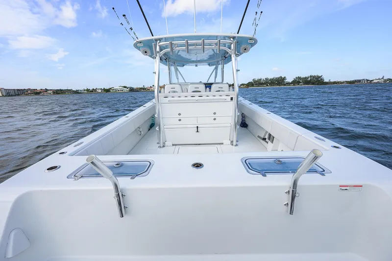 Slide: The Image of 2022 Contender 44FA boat on water, showcasing spacious deck and fishing rod holders. - 28