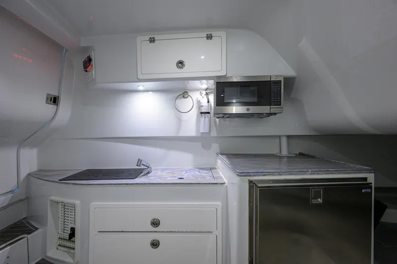 Slide: The Image of Modern kitchen area in 2022 Contender 44FA boat with microwave and storage. - 39