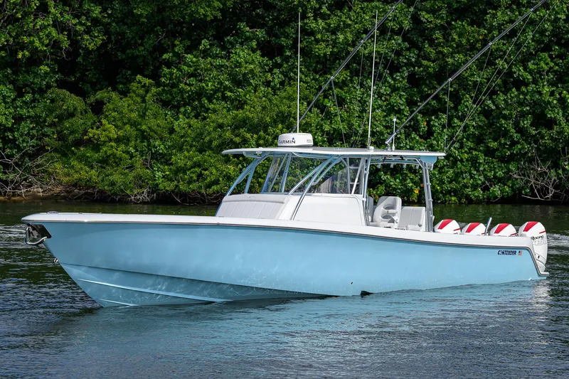 Slide: The Image of 2022 Contender 44FA boat on water, surrounded by lush greenery. - 4