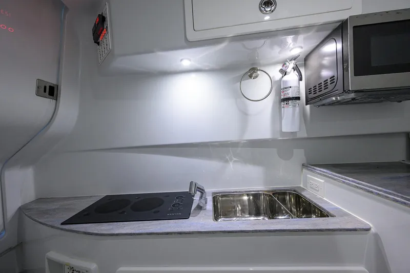 Slide: The Image of Modern kitchen area in 2022 Contender 44FA boat with stove, sink, and microwave. - 40
