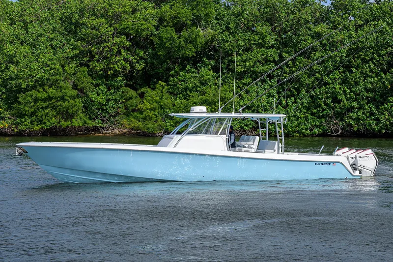 Slide: The Image of 2022 Contender 44FA boat on water, surrounded by lush greenery. - 6