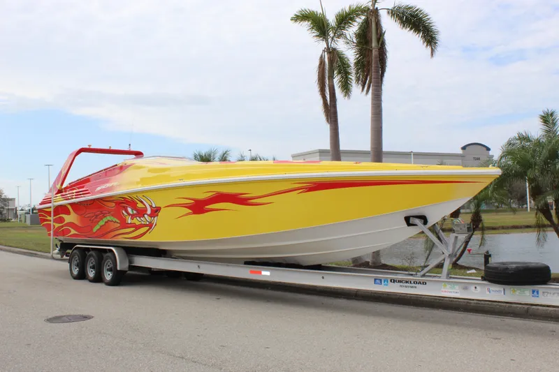 Slide: The Image of 2001 Sonic 42 SS speedboat with vibrant yellow and red flame design on a trailer. - 11