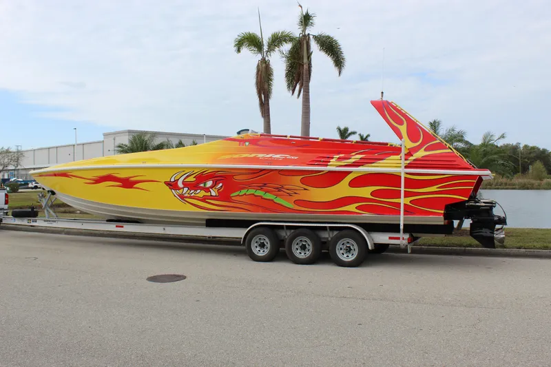 Slide: The Image of 2001 Sonic 42 SS speedboat with vibrant dragon and flame design on trailer. - 2