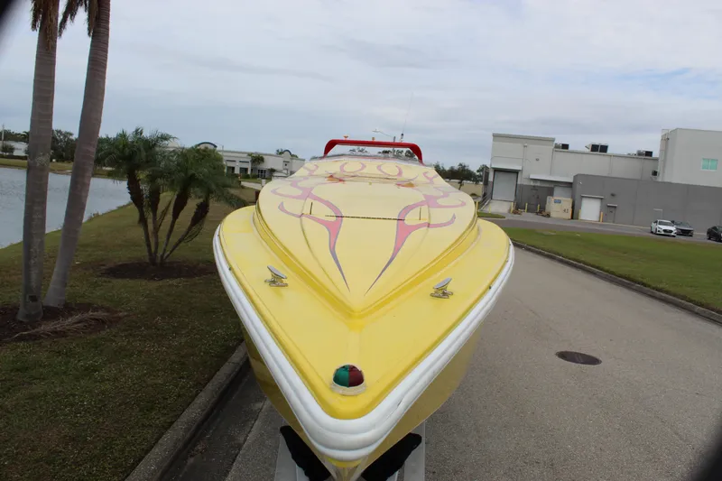 Slide: The Image of Yellow 2001 Sonic 42 SS speedboat with red accents, parked near palm trees and industrial buildings. - 21