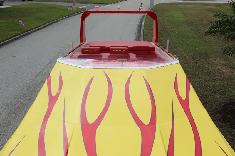Slide: The Image of 2001 Sonic 42 SS boat with vibrant yellow and red flame design on the deck. - 23