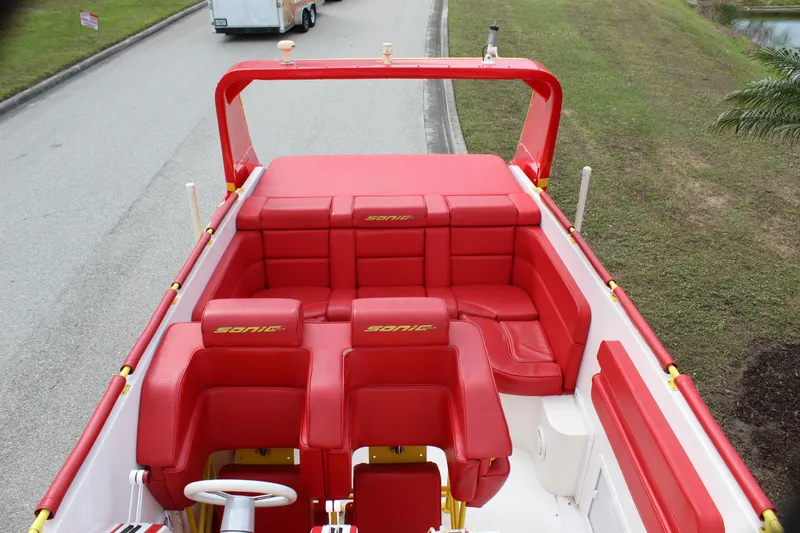 Slide: The Image of Red interior of 2001 Sonic 42 SS boat with seating and steering wheel. - 25