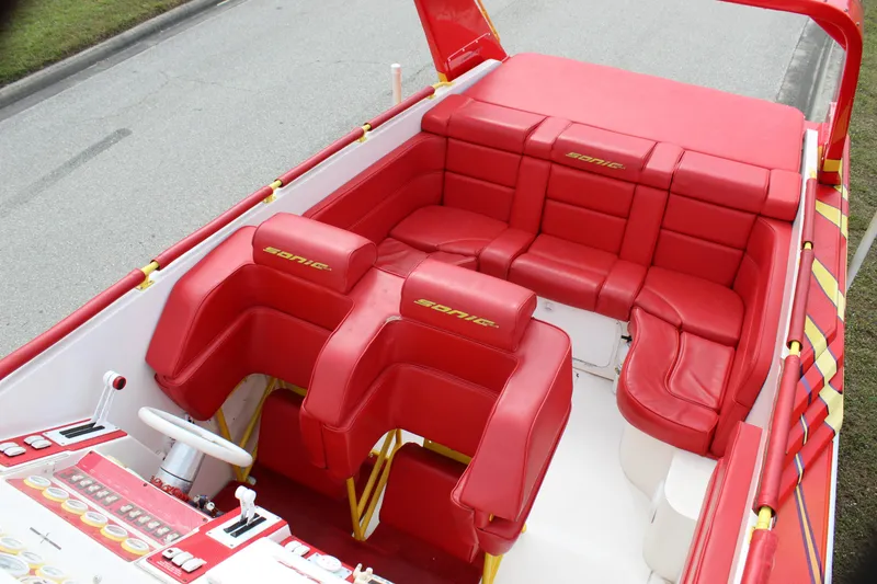 Slide: The Image of Red interior of 2001 Sonic 42 SS boat with cushioned seating and control panel. - 26