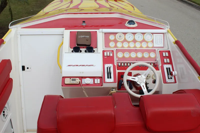 Slide: The Image of 2001 Sonic 42 SS boat dashboard with red and white controls and steering wheel. - 33