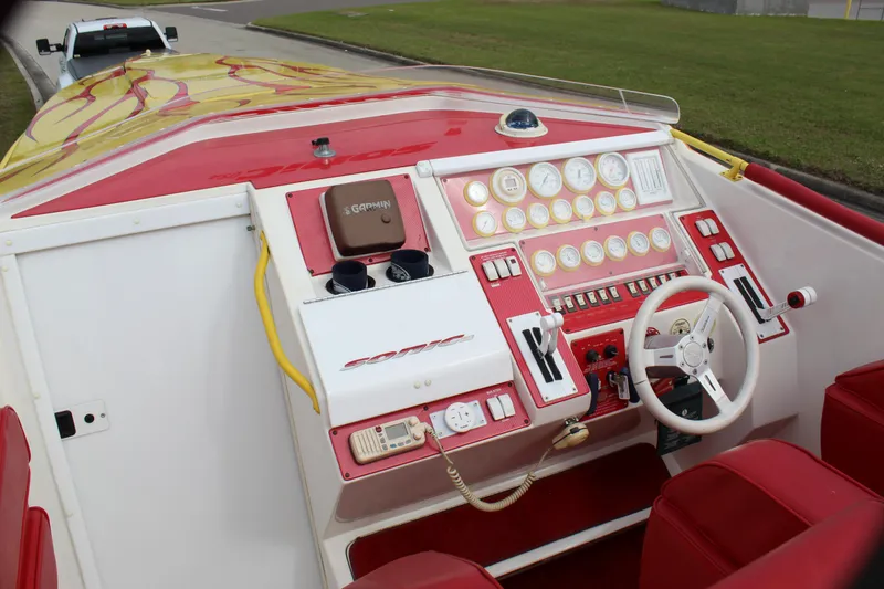Slide: The Image of 2001 Sonic 42 SS boat dashboard with red and white controls and steering wheel. - 35