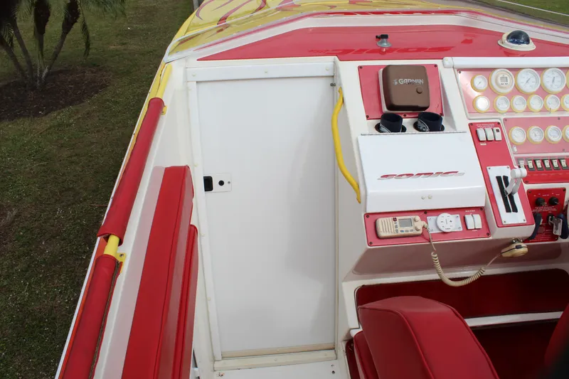 Slide: The Image of 2001 Sonic 42 SS boat cockpit with red and yellow accents, featuring control panel and seating. - 37