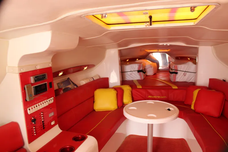 Slide: The Image of Interior of 2001 Sonic 42 SS boat with red and yellow seating, table, and control panel. - 40