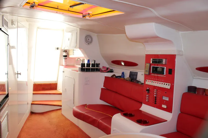 Slide: The Image of Interior of 2001 Sonic 42 SS boat with red seating and control panel. - 43