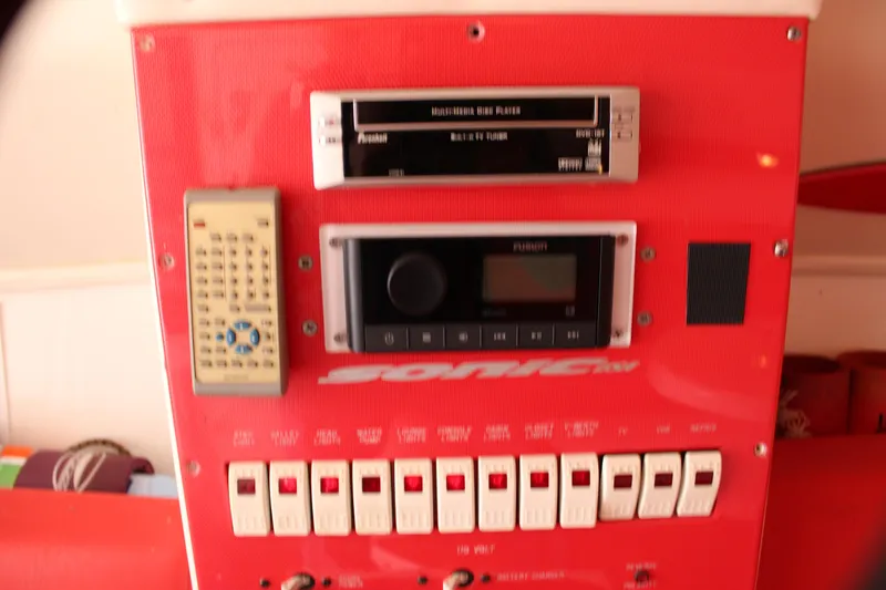 Slide: The Image of Control panel of a 2001 Sonic 42 SS boat with audio system and switches. - 49