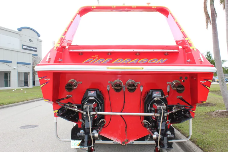 Slide: The Image of Red 2001 Sonic 42 SS boat named "Fire Dragon" with dual engines, parked near a building. - 8