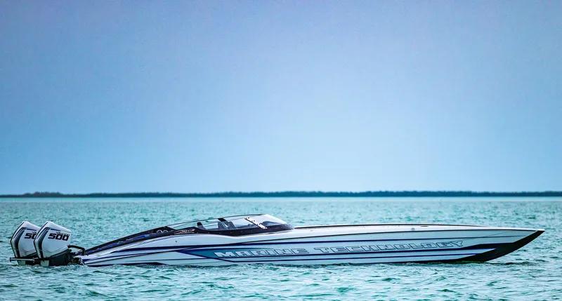 Slide: The Image of 2023 MTI 440X speedboat on calm blue water with twin engines. - 6