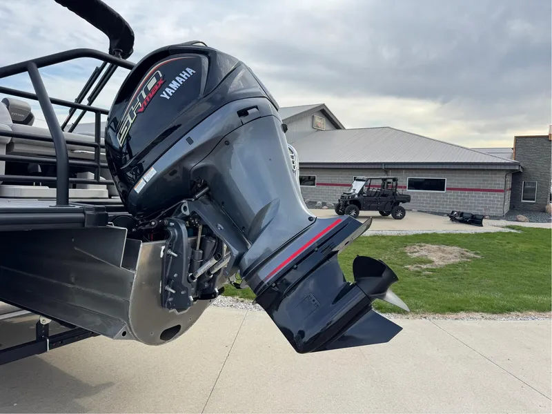 Slide: The Image of 2023 Sylvan L5 DLZ Bar with Yamaha outboard motor, parked near a building. - 15