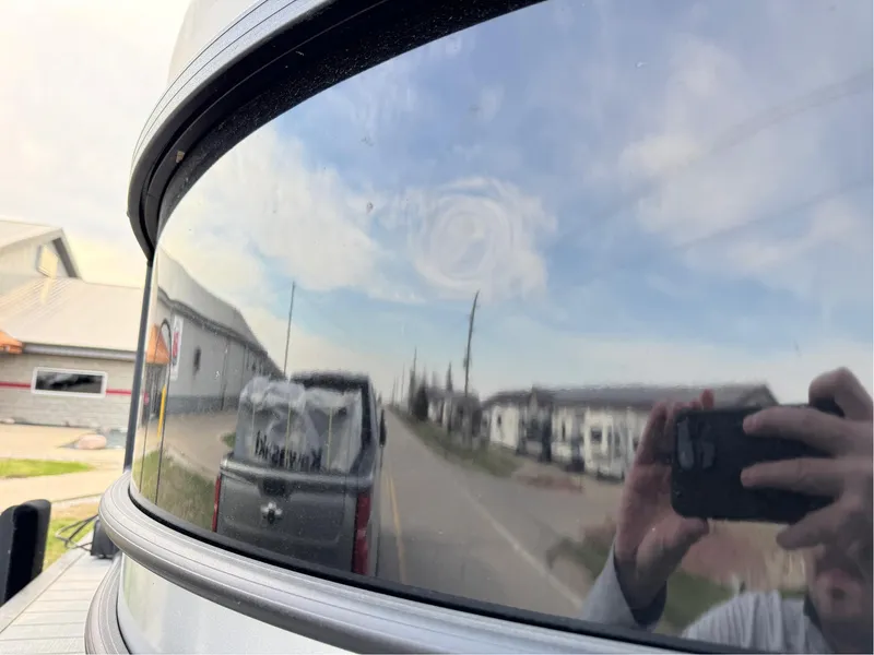 Slide: The Image of Reflection on Sylvan L5 DLZ Bar 2023 boat, capturing road and buildings. - 17