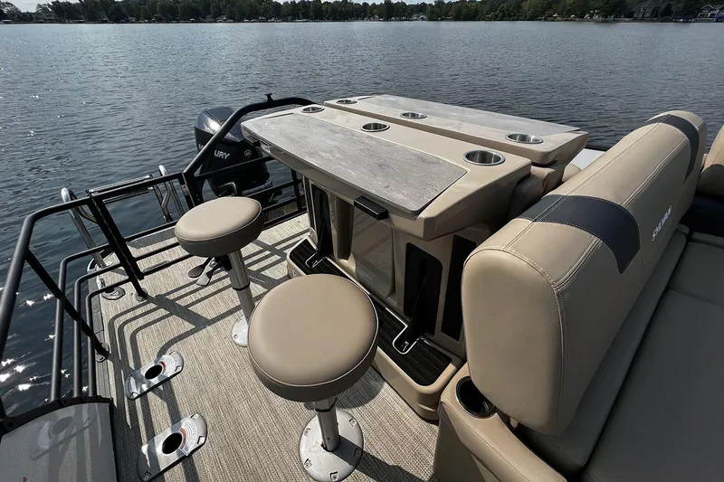 Slide: The Image of 2023 Sylvan L5 DLZ Bar pontoon boat with bar seating on a calm lake. - 37