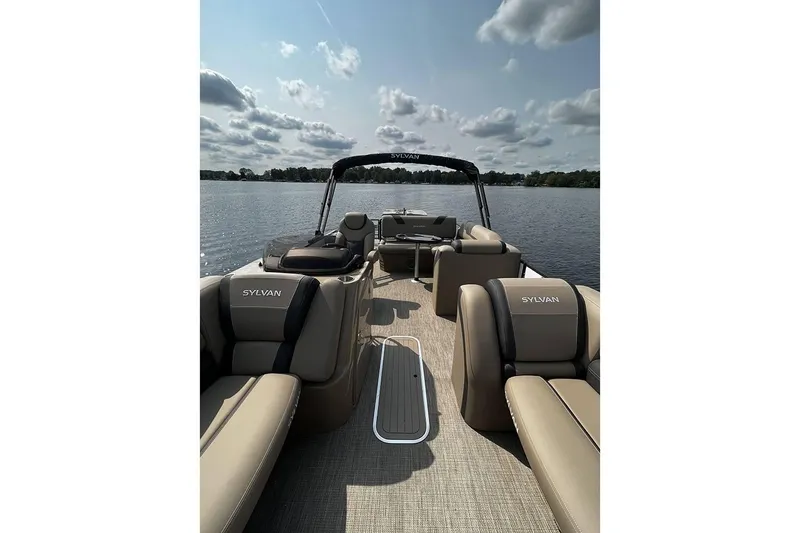 Slide: The Image of 2023 Sylvan L5 DLZ Bar pontoon boat on a calm lake under a cloudy sky. - 39