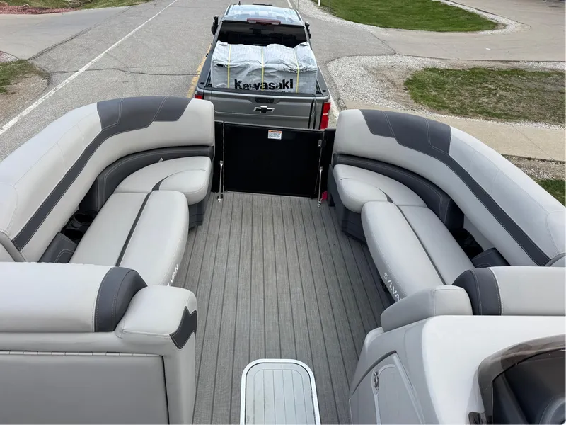 Slide: The Image of 2023 Sylvan L5 DLZ Bar pontoon boat with spacious seating, parked on a trailer. - 7