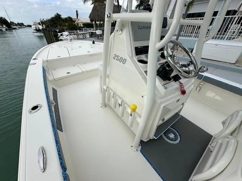 Slide: The Image of 2021 Pathfinder 2500 Hybrid boat interior with steering console and seating, docked by the water. - 10