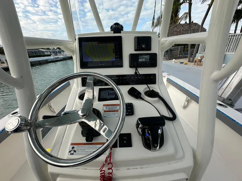 Slide: The Image of Pathfinder 2500 Hybrid 2021 boat console with steering wheel, navigation screens, and controls. - 12