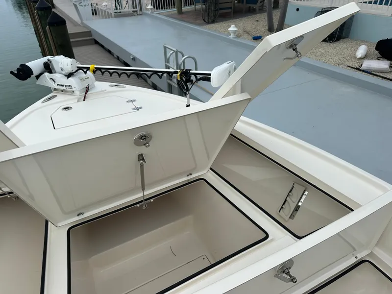 Slide: The Image of Open storage compartments on a 2021 Pathfinder 2500 Hybrid boat docked by the water. - 22