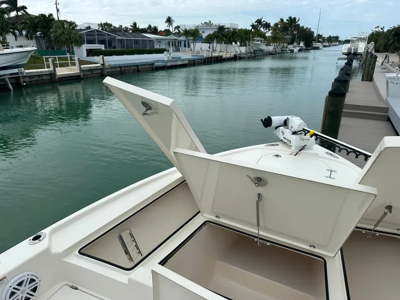 Slide: The Image of Pathfinder 2500 Hybrid 2021 boat with open storage compartments on a calm canal. - 23