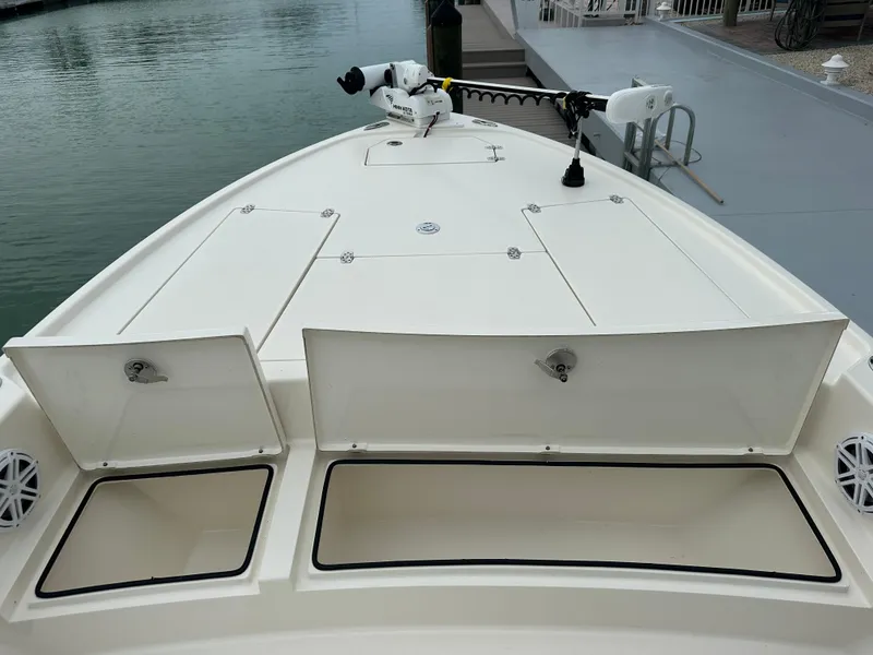 Slide: The Image of 2021 Pathfinder 2500 Hybrid boat deck with open storage compartments at a marina. - 25