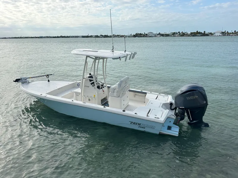 Slide: The Image of 2021 Pathfinder 2500 Hybrid boat on calm water, featuring a sleek design and outboard motor. - 6