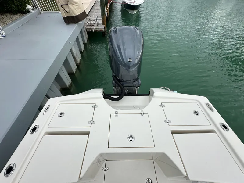 Slide: The Image of 2021 Pathfinder 2500 Hybrid boat stern with outboard motor, docked on calm water. - 7