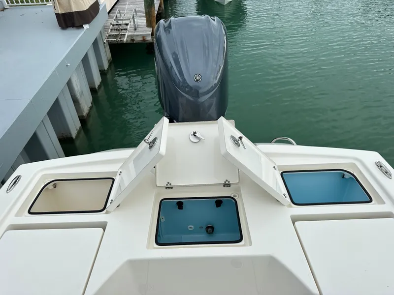 Slide: The Image of 2021 Pathfinder 2500 Hybrid boat with open storage compartments and outboard motor. - 8