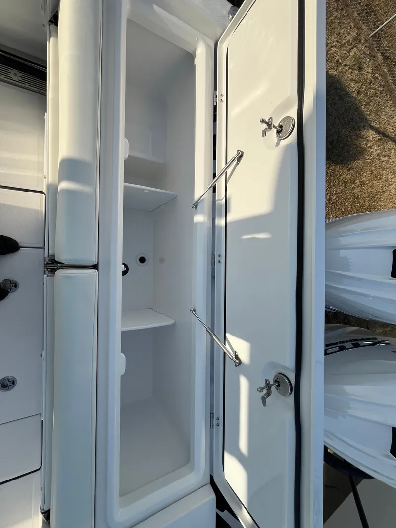 Slide: The Image of 2025 Everglades 335 Center Console storage compartment, open with dual latches and spacious interior. - 13