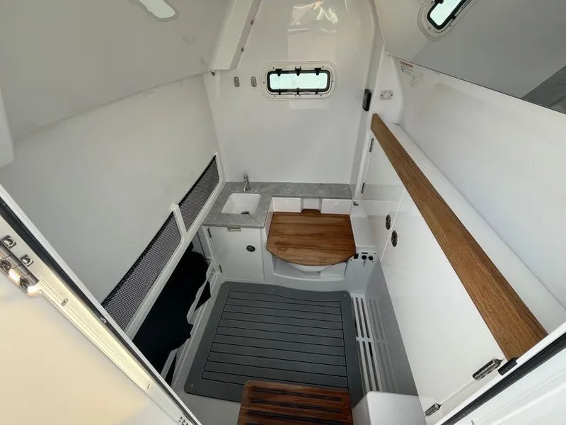 Slide: The Image of 2025 Everglades 335 Center Console cabin interior with sink and wooden accents. - 16