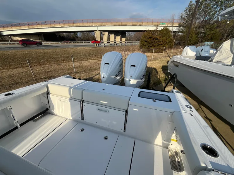 Slide: The Image of 2025 Everglades 335 Center Console boat with dual engines, parked near a highway. - 17