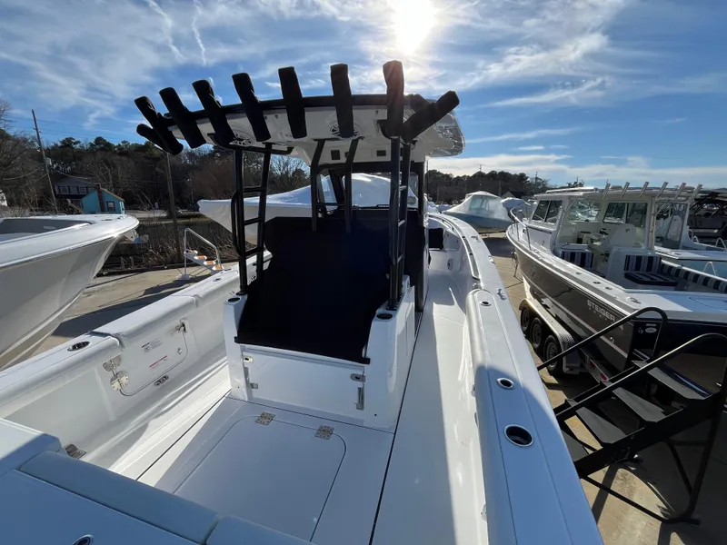 Slide: The Image of 2025 Everglades 335 Center Console boat, docked under a bright sky. - 5