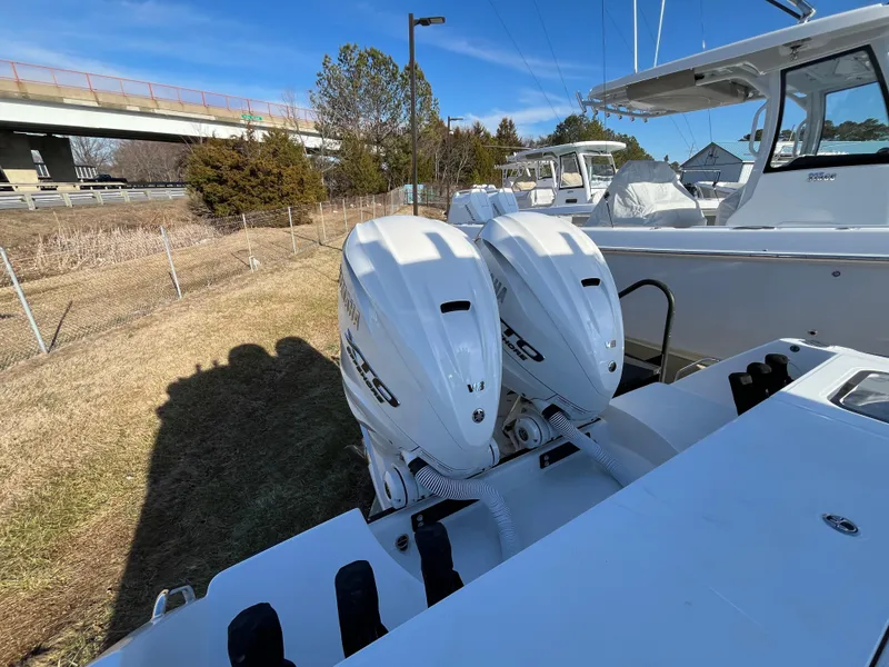 Slide: The Image of 2025 Everglades 335 Center Console with dual outboard engines, parked outdoors. - 8