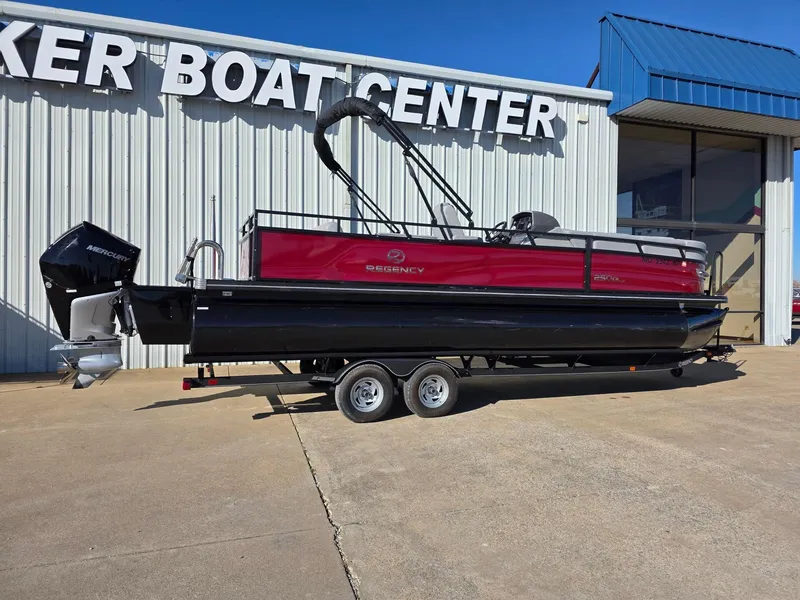 The Image of 2023 Regency 250 DL3 pontoon boat on trailer outside dealership. - 1